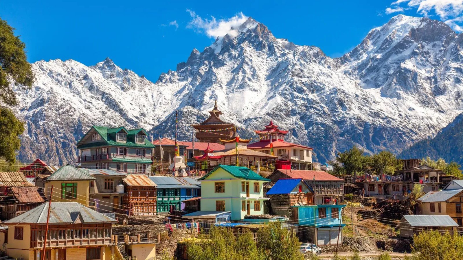 An aerial view of a cricket stadium nestled amidst picturesque mountains.